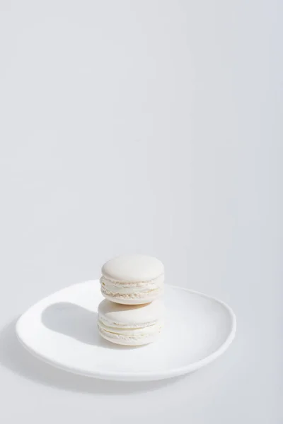 Macarons saborosos e doces na placa isolada em branco — Fotografia de Stock