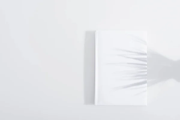 Shadow on hardcover of book on white background — Stock Photo