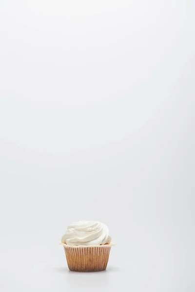Gebackener Cupcake mit Sahnehäubchen auf weißem Hintergrund — Stockfoto