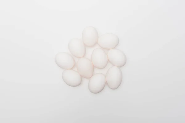 Vista superior de ovos crus e biológicos isolados em branco — Fotografia de Stock