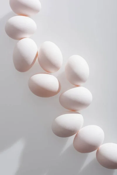 Vista dall'alto di uova biologiche in guscio su sfondo bianco — Foto stock