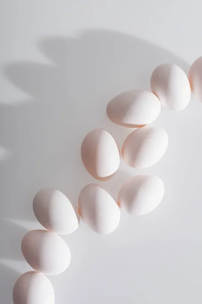 Top view of fresh and organic eggs in shell on white — Stock Photo