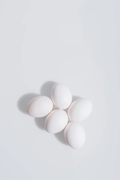 Vista superior de ovos não cozidos e biológicos com casca sobre fundo branco — Fotografia de Stock