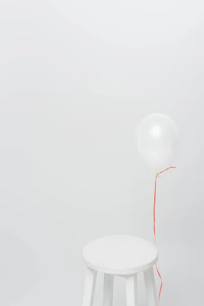 Ballon léger près de chaise en bois isolé sur blanc — Photo de stock