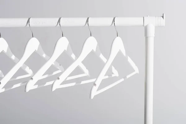 White hangers on clothes rack isolated on grey — Stock Photo