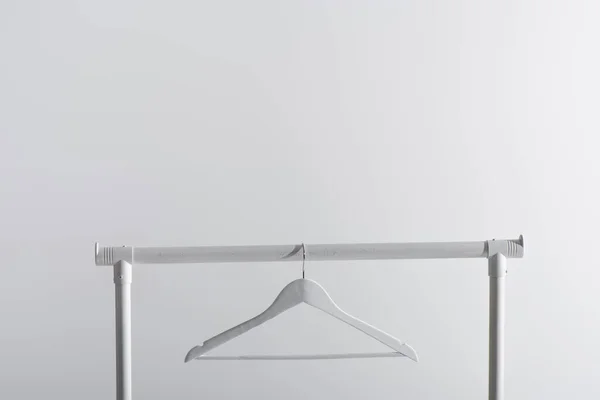 Single white hanger on garment rack isolated on grey — Stock Photo