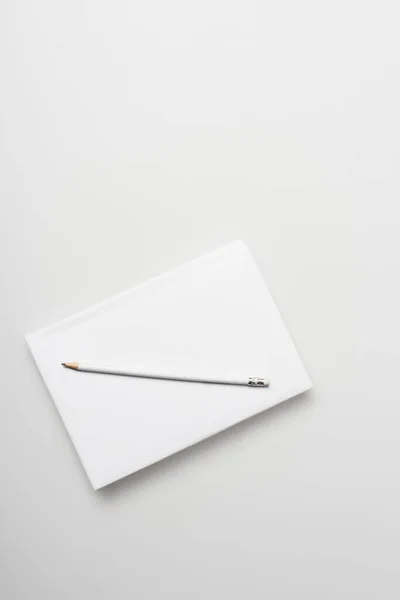 Top view of notepad in hardcover with pencil isolated on white — Stock Photo