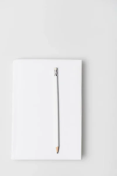 Top view of pencil on notebook in hardcover isolated on white — Stock Photo