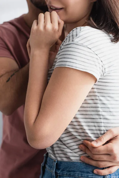 Teilbild: Junger Mann umarmt Freundin zu Hause mit Händen in Gesichtsnähe — Stockfoto