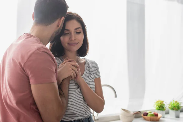 Joven morena pareja suavemente cogido de la mano en cocina - foto de stock