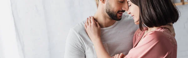 Glückliches junges Paar umarmt sich sanft im Schlafzimmer, Banner — Stockfoto