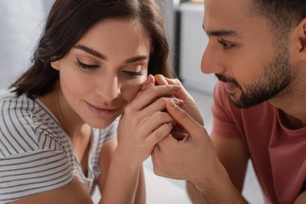 Close up view of young man gently touching hands near face of girlfriend at home — Stock Photo