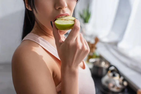 Cropped view of young woman biting apple — Stock Photo