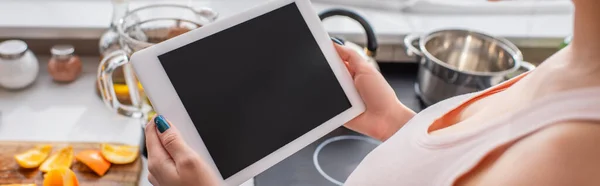 Visión parcial de la mujer borrosa utilizando tableta digital en la cocina, bandera - foto de stock