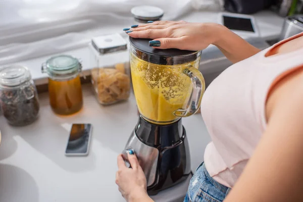 Cropped view of woman preparing smoothie in kitchen — Stock Photo