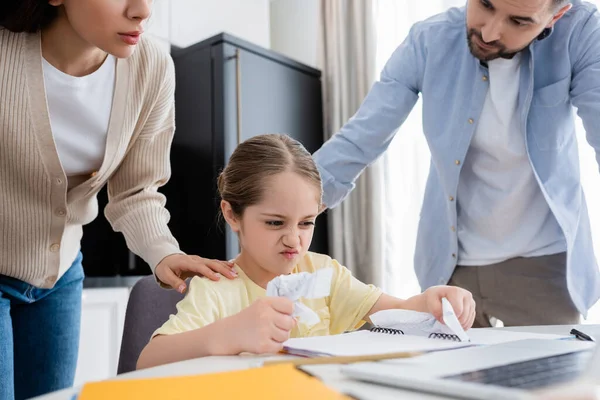 Paar beruhigt wütendes Kind beim Zerknüllen von Papier bei Hausaufgaben — Stockfoto