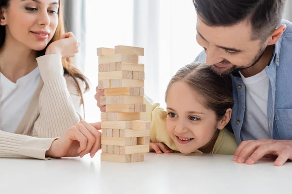 Cheerful family playing wood blocks game at home — Stock Photo