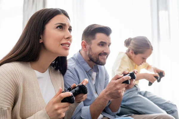 KYIV, UKRAINE - APRIL 8, 2021: concentrated family gaming with joysticks at home — Stock Photo