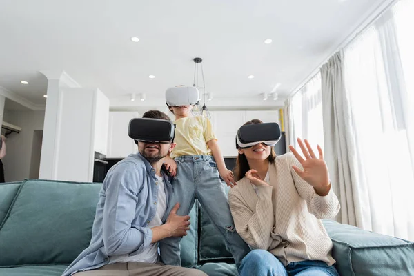 Испуганные семейные игры в виртуальных наушниках на диване в гостиной — стоковое фото