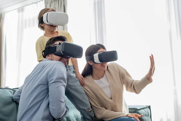 Frau gestikuliert mit verängstigter Familie beim Spielen in Vr-Headsets — Stockfoto