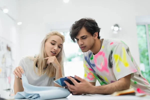 Couple de jeunes créateurs de mode choisissant la couleur de la palette dans le magasin de tailleur — Photo de stock