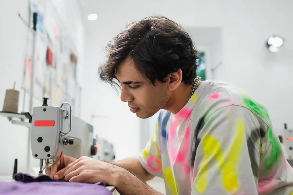 Sastre elegante que trabaja en la máquina de coser en sastrería - foto de stock