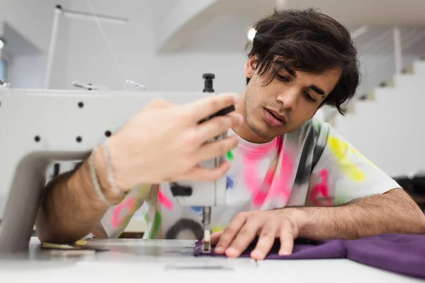 Moda alfaiate ajustando máquina de costura enquanto trabalhava no atelier — Fotografia de Stock