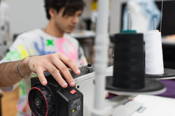 Tailleurs flous ajustant la machine à coudre tout en travaillant en atelier — Photo de stock