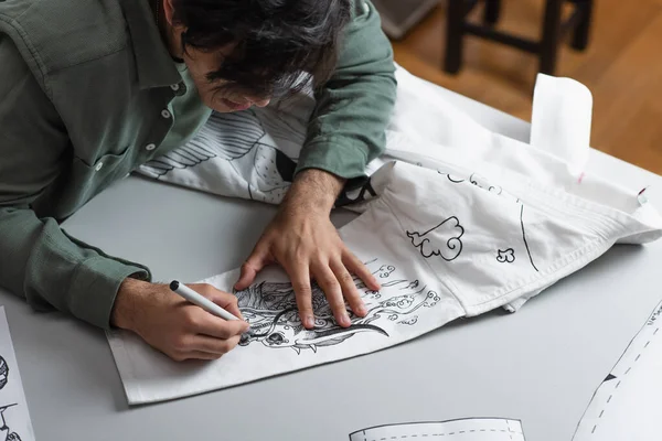 Creative fashion designer creating traditional drawing on kimono — Stock Photo