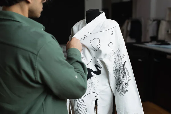 Visão parcial do designer de moda borrada perto de quimono com desenho tradicional no manequim — Fotografia de Stock