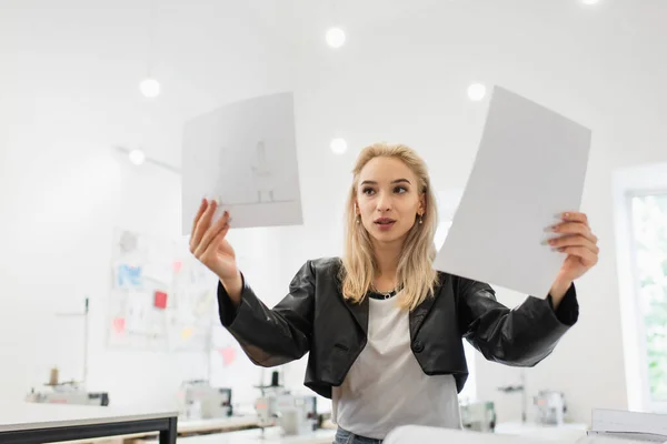 Модний дизайнер моди, дивлячись на малюнки в кравецькому магазині — Stock Photo