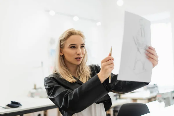 Junge Modedesignerin misst die Proportionen der Zeichnung mit Bleistift — Stockfoto