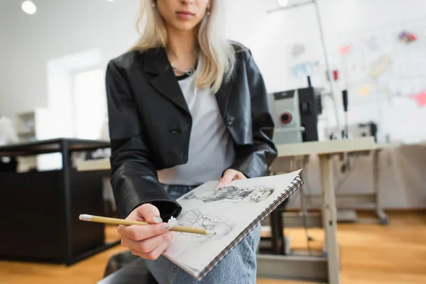 Vista recortada de dibujo creativo diseñador de moda en cuaderno de dibujo en taller - foto de stock