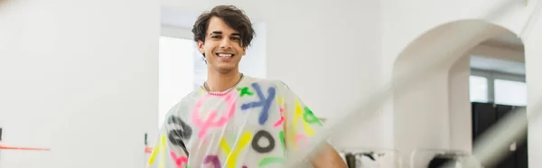 Щасливий і модний дизайнер посміхається на камеру в майстерні моди, банер — стокове фото