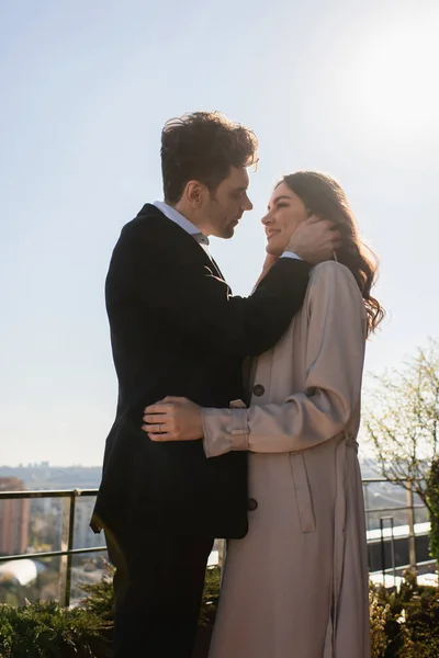 Man and happy woman hugging and looking at each other on terrace of restaurant — Stock Photo