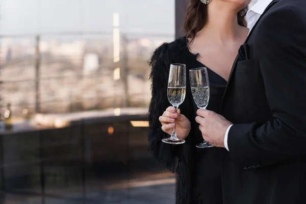 Partial view of man and woman clinking glasses of champagne — Stock Photo