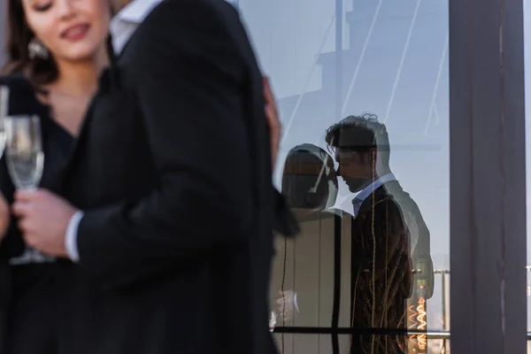 Silhouette of loving couple in glass of window with blurred foreground — Stock Photo