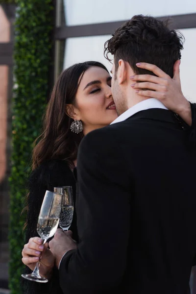 Homme et femme cliquetis verres de champagne et baisers à l'extérieur — Photo de stock