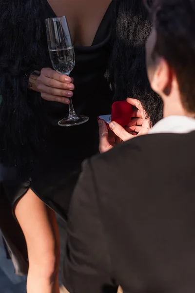 Ausgeschnittene Ansicht eines Mannes, der Frau mit einem Glas Champagner einen Heiratsantrag macht — Stockfoto