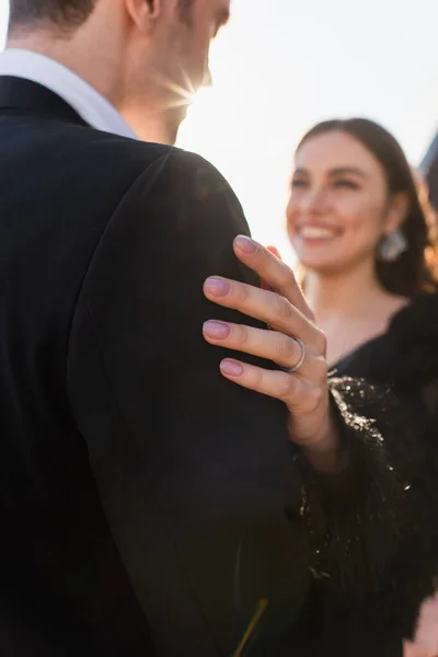 Смутная и счастливая женщина, обнимающая мужчину на улице — стоковое фото
