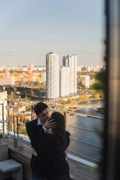 Мужчина целует женщину на крыше ресторана — стоковое фото
