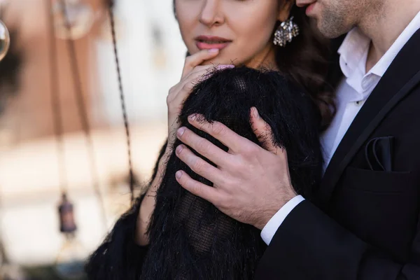 Cropped view of man embracing woman in faux fur coat — Stock Photo