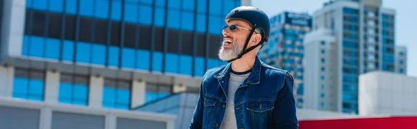 Smiling and middle aged man in helmet and sunglasses in city, banner — Foto stock