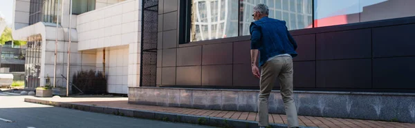 Back view of mature man on urban street, banner — Stock Photo