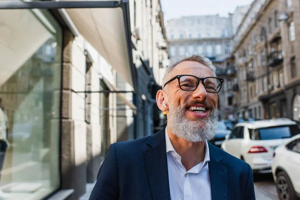 Happy mature man listening music in earphones outside — Photo de stock