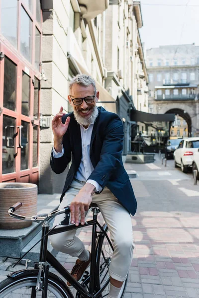 Happy man listening music in earphones and riding bicycle - foto de stock