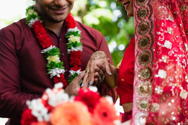 Vista recortada de hombre indio feliz con anillo de boda en el dedo de la novia - foto de stock