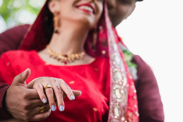 Partial view of happy indian man holding hand of bride with wedding ring on finger — Stock Photo