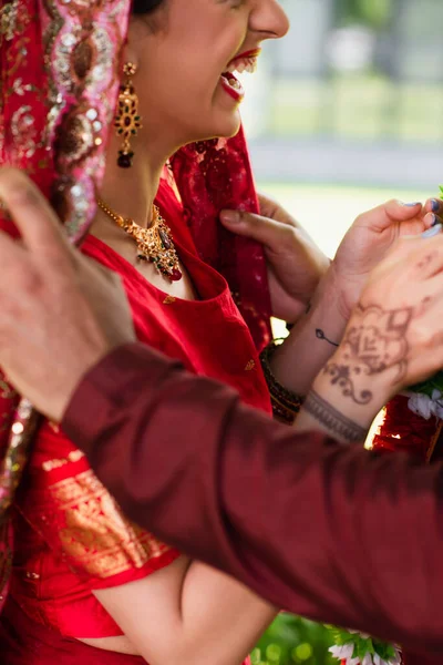 Vue recadrée de joyeuse mariée indienne riant près du marié — Photo de stock