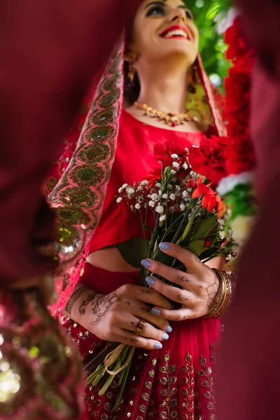 Низький кут зору щасливої індійської нареченої, дивлячись на розмитого чоловіка — стокове фото